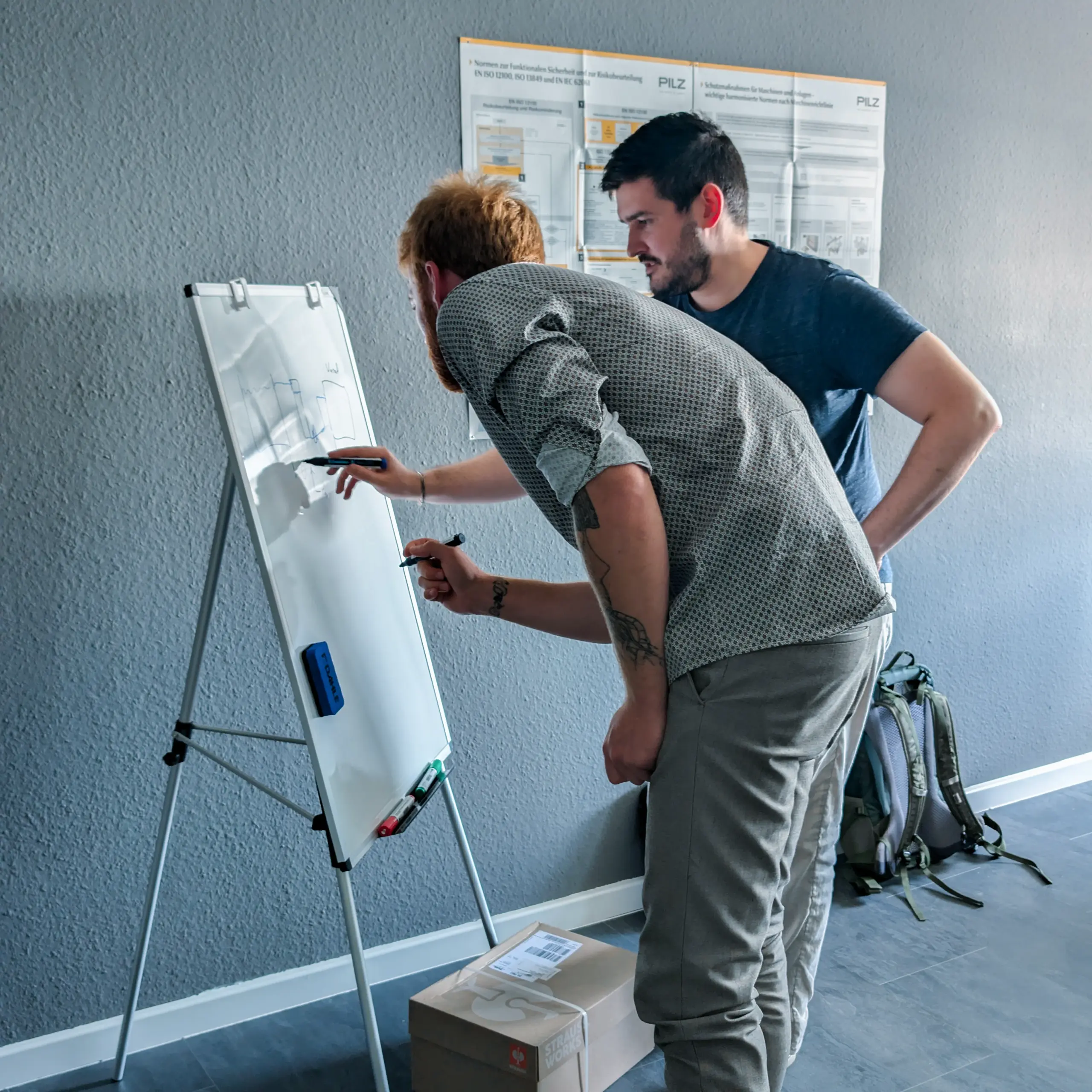 Zwei NEERTEX-Ingenieure entwickeln ein technisches Konzept am Whiteboard