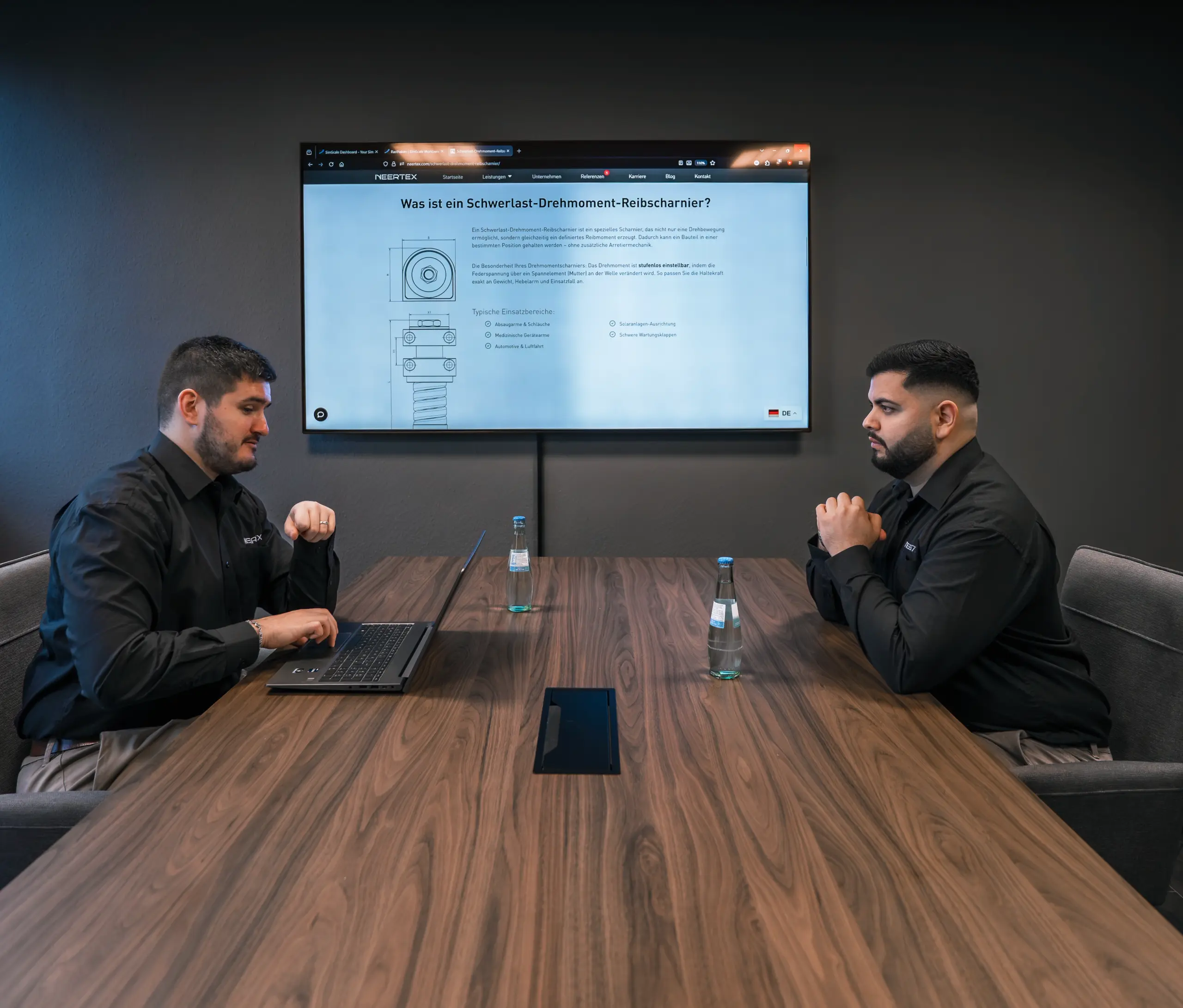 Zwei NEERTEX-Ingenieure besprechen die Entwicklung eines technischen Produkts anhand einer Konstruktionszeichnung